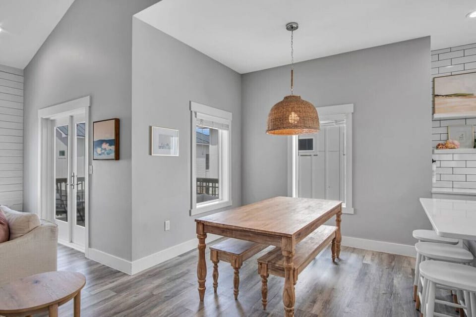 The dining area features a table with bench seating as well as 3 bar stools at the kitchen island.
