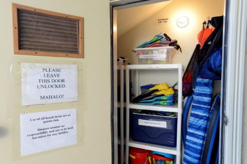 Your vacation essentials are thoughtfully organized in this storage area, stocked with colorful beach gear, snorkeling fins, and water toys ready for your island adventures.