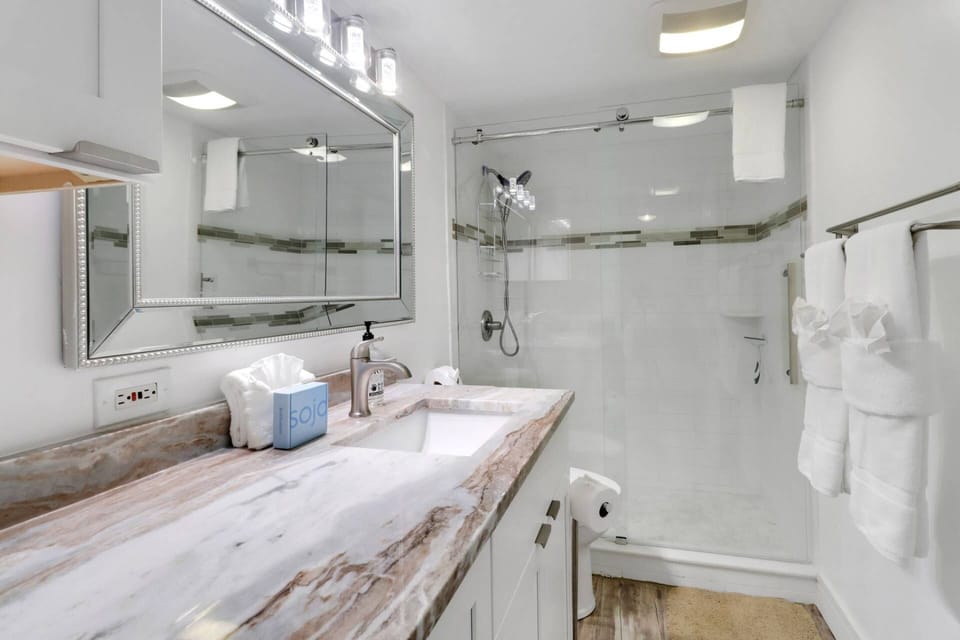 This beautiful bathroom features a spacious vanity counter and a large walk in shower.