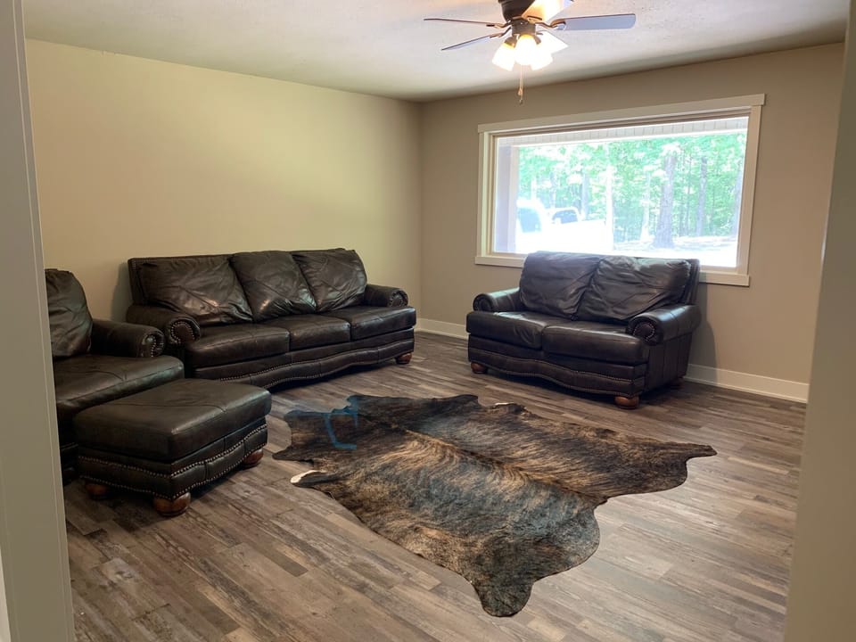 front living area with couch, loveseat, oversize chair, and TV