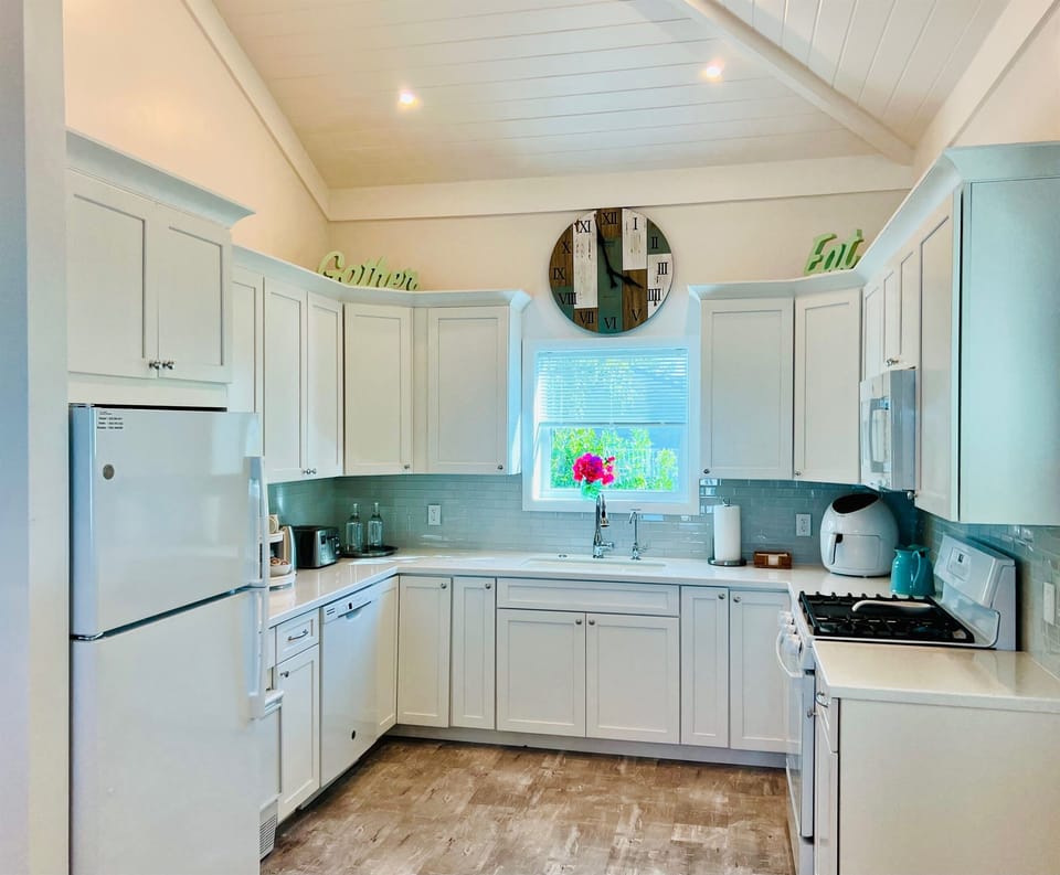 Kitchen includes Full size refrigerator/freezer, self standing ice maker, 4 burner and griddle gas range with gas oven, dishwasher, large sink with garbage disposal and microwave.
