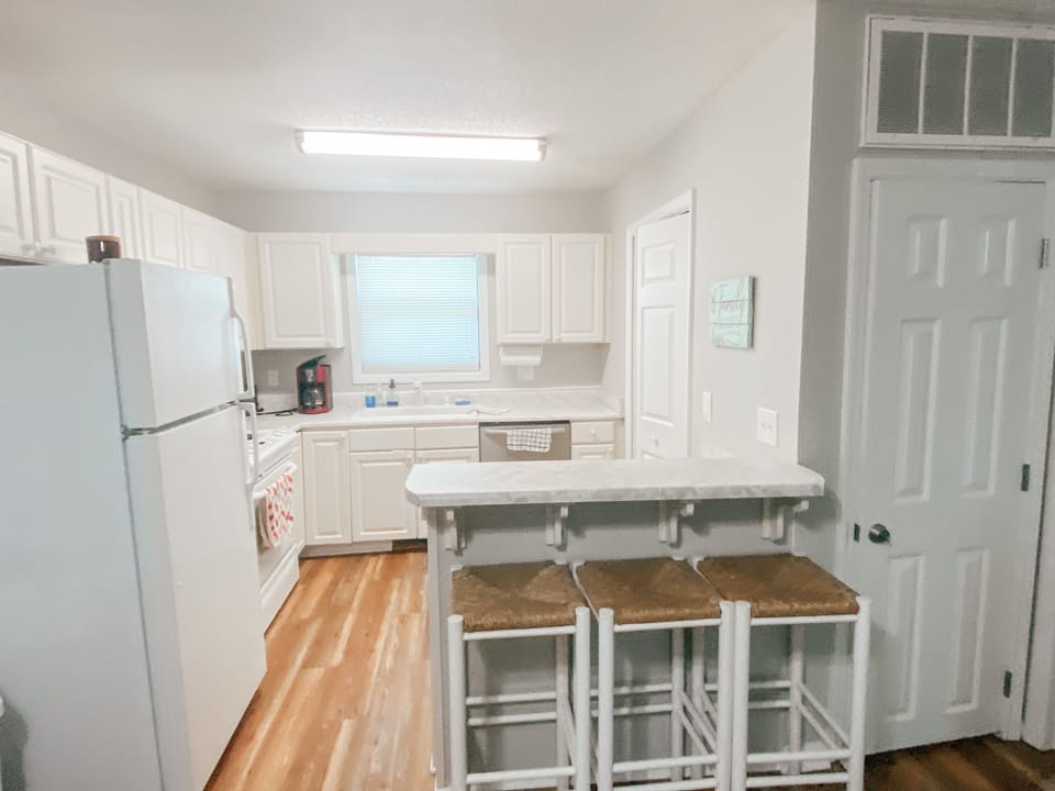 The kitchen has a breakfast bar with 3 bar stools.