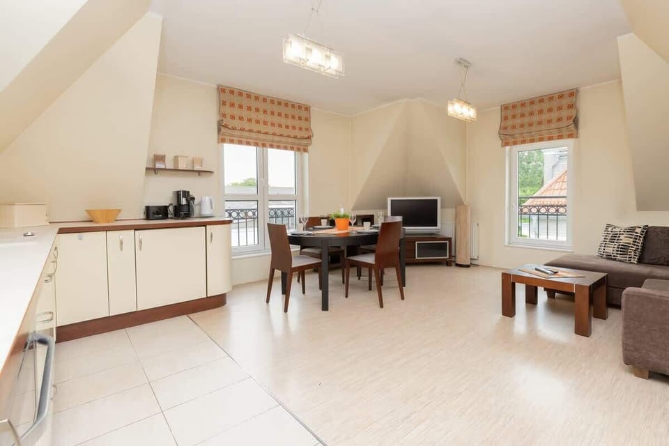 A harmonious combination of seating area and kitchenette. The whole is complemented by a wooden dining table with chairs.
