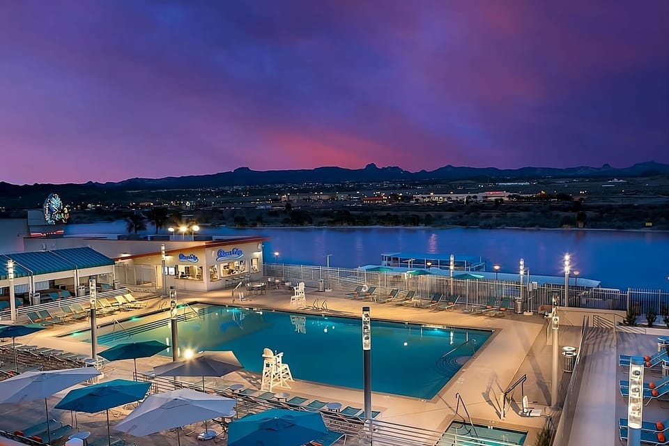 Unwind poolside at sunset with shimmering waterfront views.