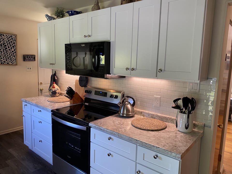 Other side of kitchen. Microwave, stove.
