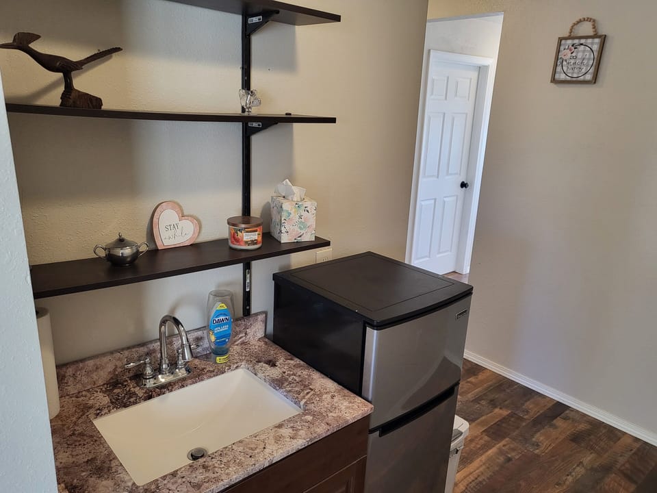 Upstairs wet bar with Refrigerator and sink, also includes an ice bucket.
