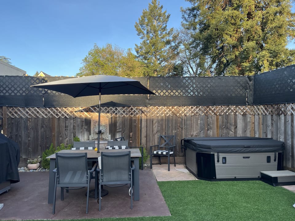 Yard with turf and new hot tub as of March 2024