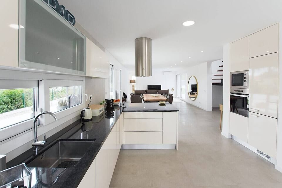 Modern open-plan kitchen with dark granite worktops — Villa das Dunas, luxury holiday villa in Sesimbra
