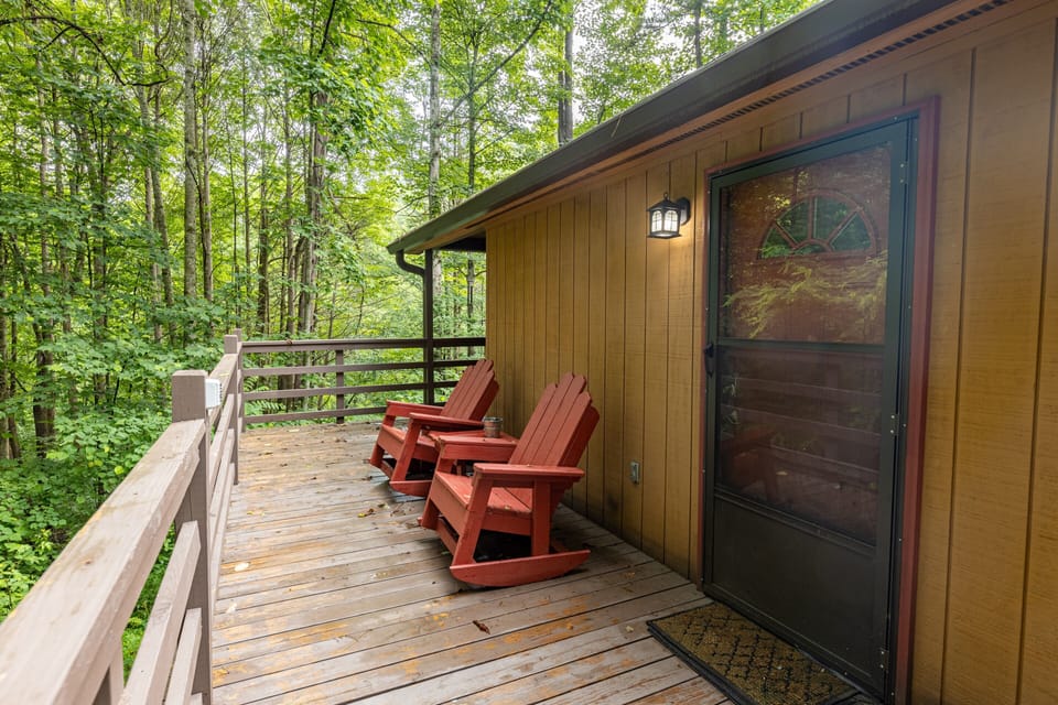 Front door with electronic lock and front porch chairs for enjoying the wooded view