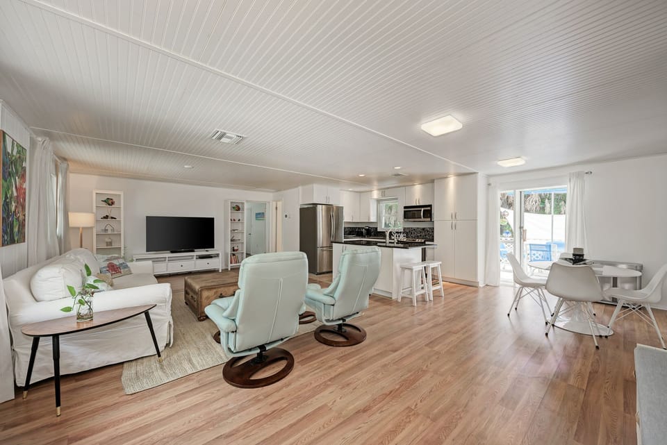 Open concept living room with kitchen and dining area. Sliding door to deck.