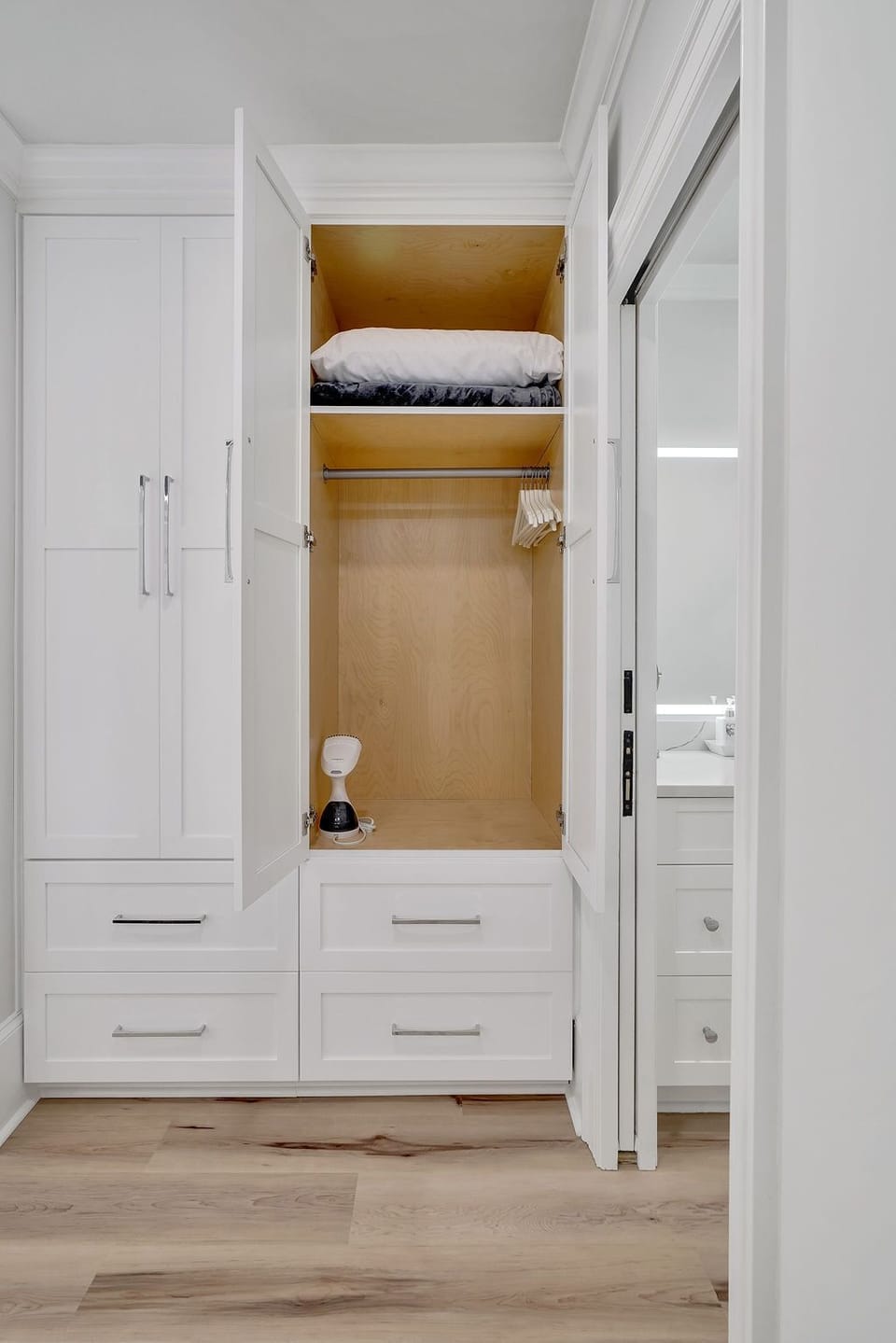 Custom closet with additional blanket, pillow, hangers and steamer.