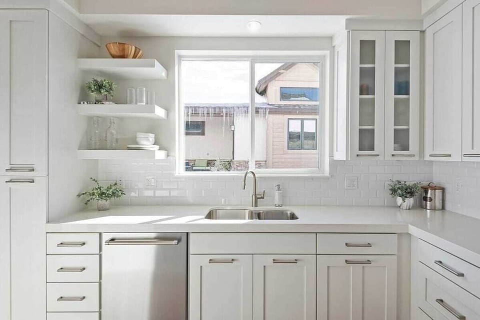 With its modern lighting, windows, quartz countertops, and stunning backsplash, the kitchen makes preparing dinner a truly enjoyable experience.