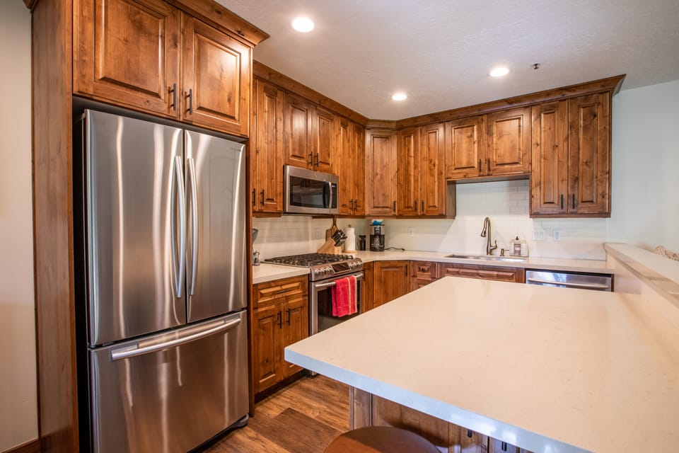 Fully stocked kitchen with stainless steel appliances.