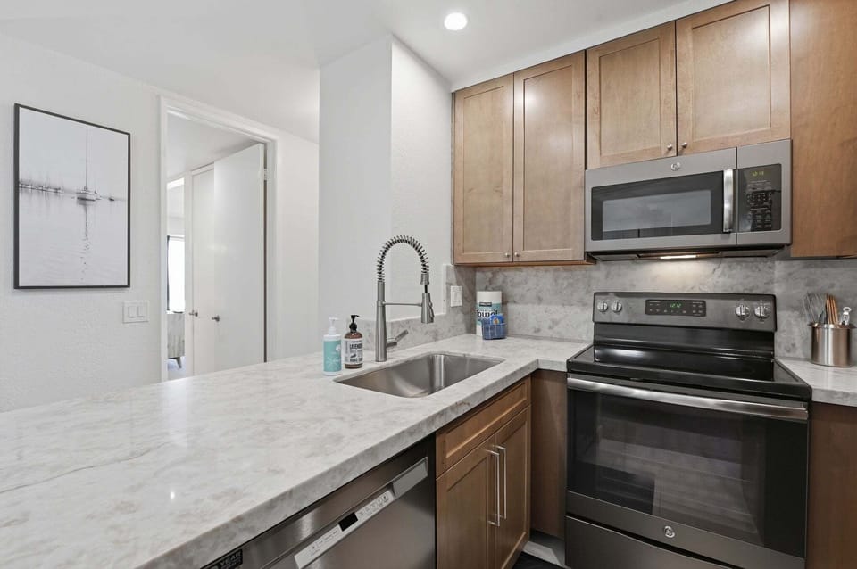 Fully stocked kitchen featuring sleek, new stainless steel appliances and all the essentials.