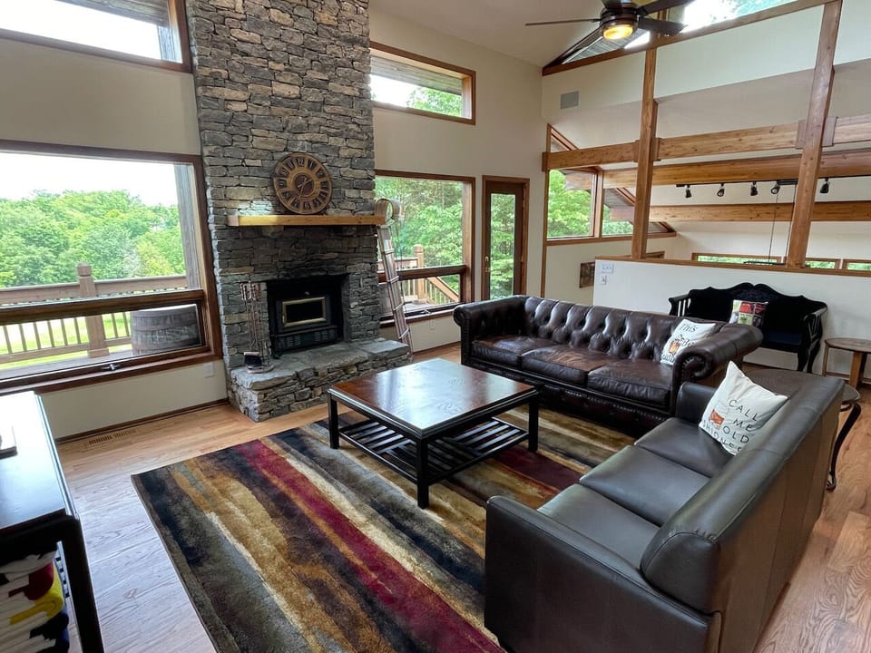 The grand entrance welcomes you. Vaulted country living room with rich leather sofas, stone real wood fireplace. Picture windows with views of the 5 acre estate.