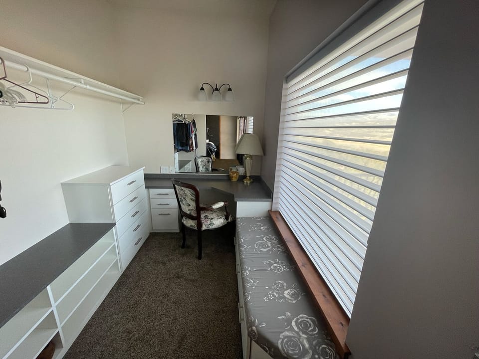 Primary bedroom closet. Desk/ chair can be used as a dedicated workspace/vanity