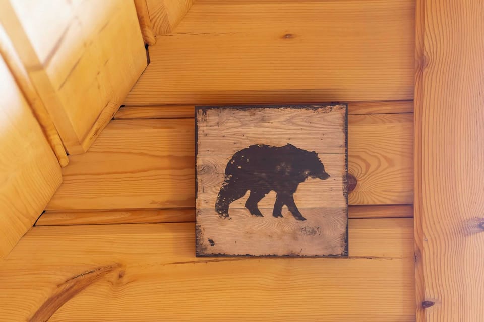 A close-up of a rustic wooden plaque with a bear illustration, adding a touch of wilderness to the decor.