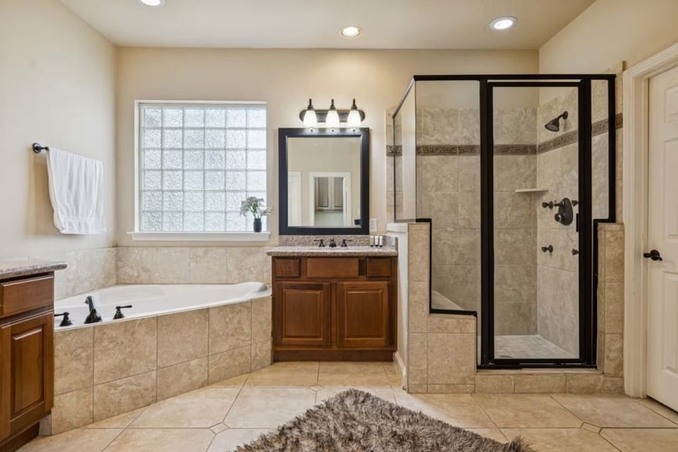 Spacious primary bathroom with dual sinks, ample vanity storage, large mirrors, and plenty of room for getting ready.