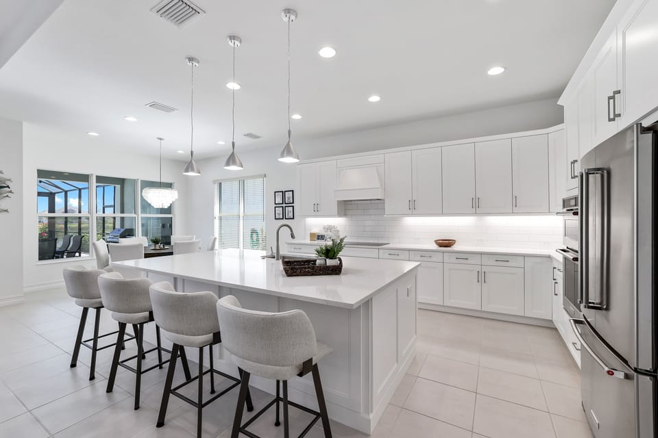 Oversized quartz kitchen island & swivel chairs.  Bright, clean, coastal.  
