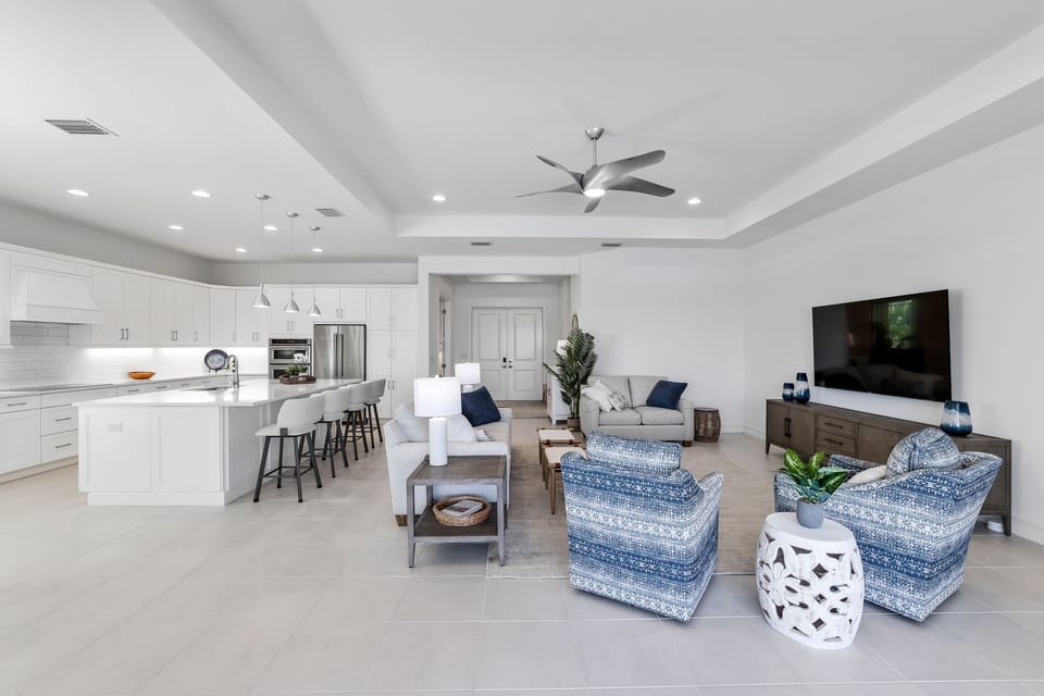 Great room with 2 sofas & 2 swivel chairs.  Kitchen island with 4 swivel chairs.