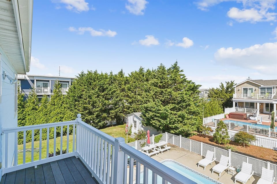 Bright residential neighborhood with mature trees and nearby homes, offering a peaceful coastal community setting for your getaway.