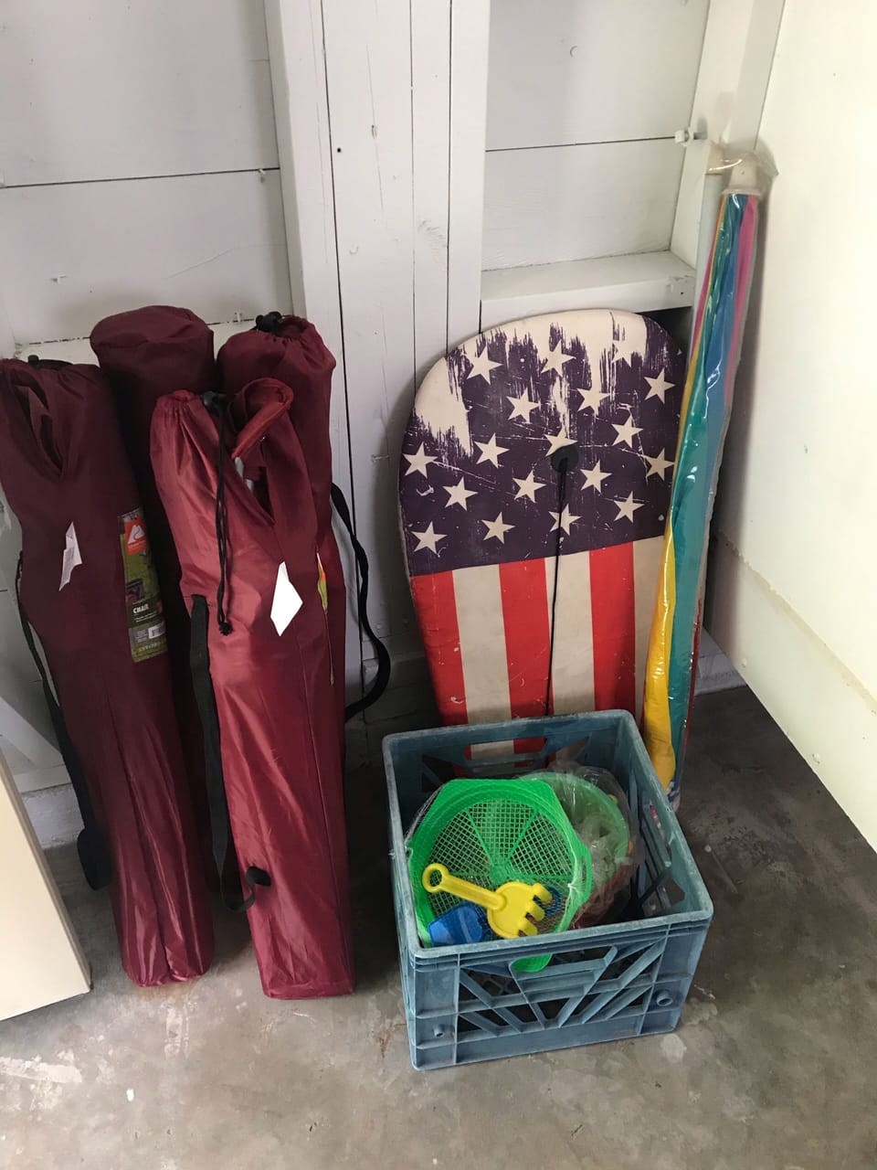 Lawn chairs and beach toys located in laundry area.