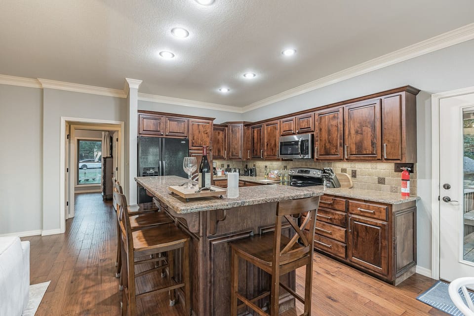 KITCHEN-4 barstools island with garbage disposal, spices, and pots and pans 