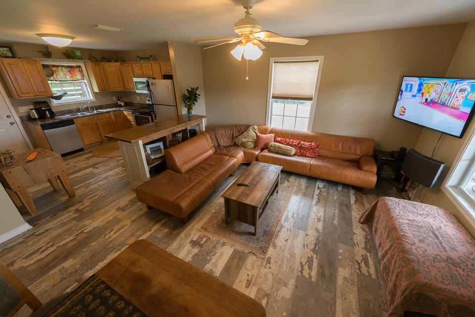 The living room with the kitchen in the background