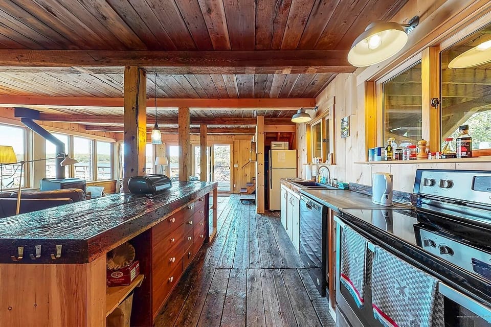 Open kitchen and reclaimed wood bar are perfect for preparing meals.