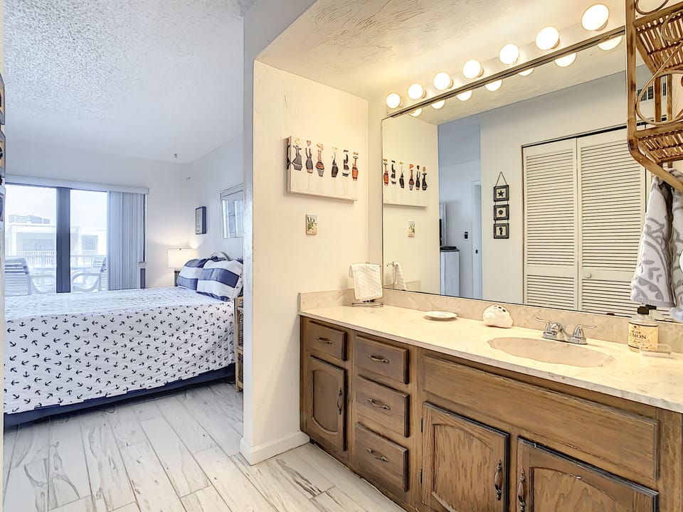 Bathroom counter with dark wood cabinets and extra large mirror