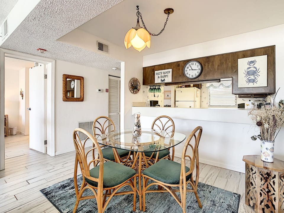 Dining room with blue rug and glass table