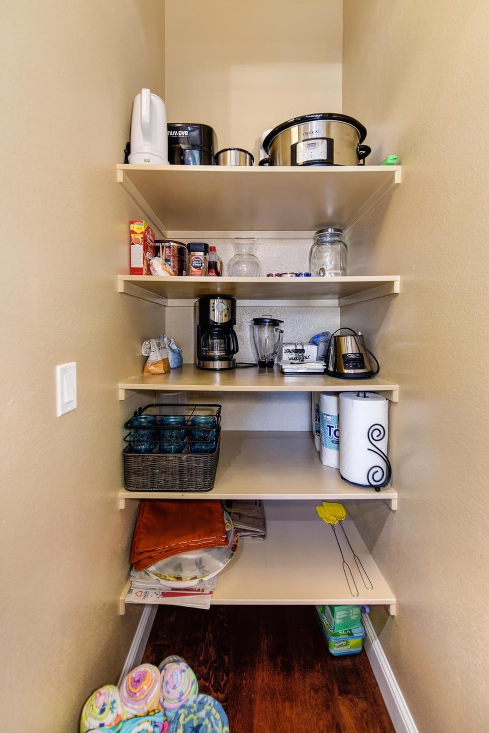 Air fryer, crockpot, drip coffee maker, blender and pool towels in the pantry