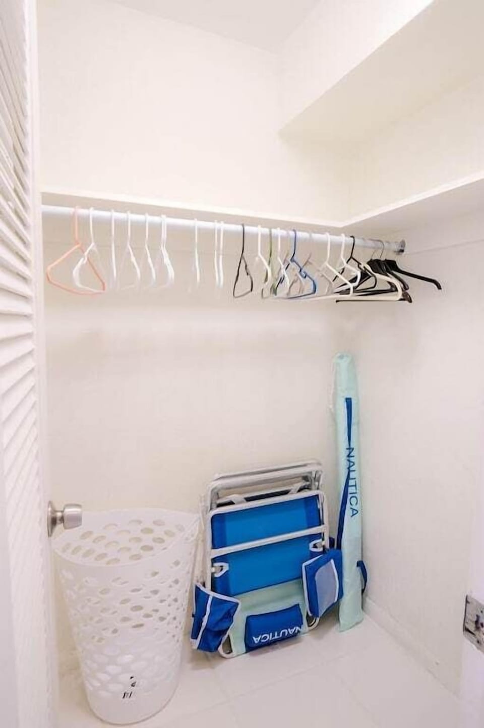 1st bedroom walk-in closet with plenty of hangers, beach chairs & beach umbrella