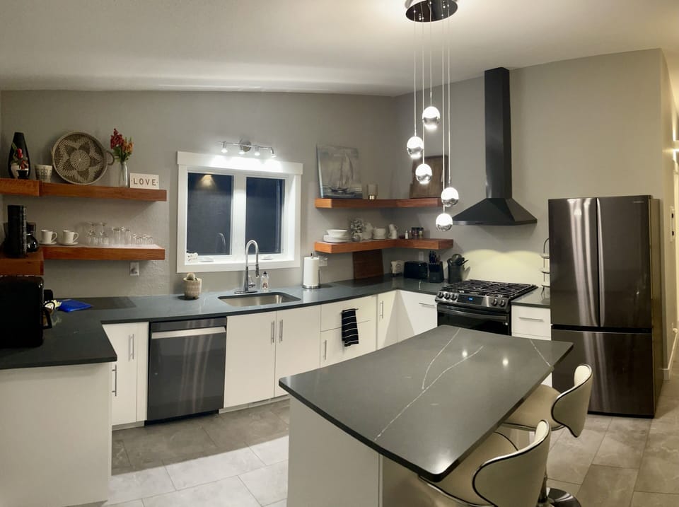 Bright kitchen with quartz counter tops and island seating for 2.