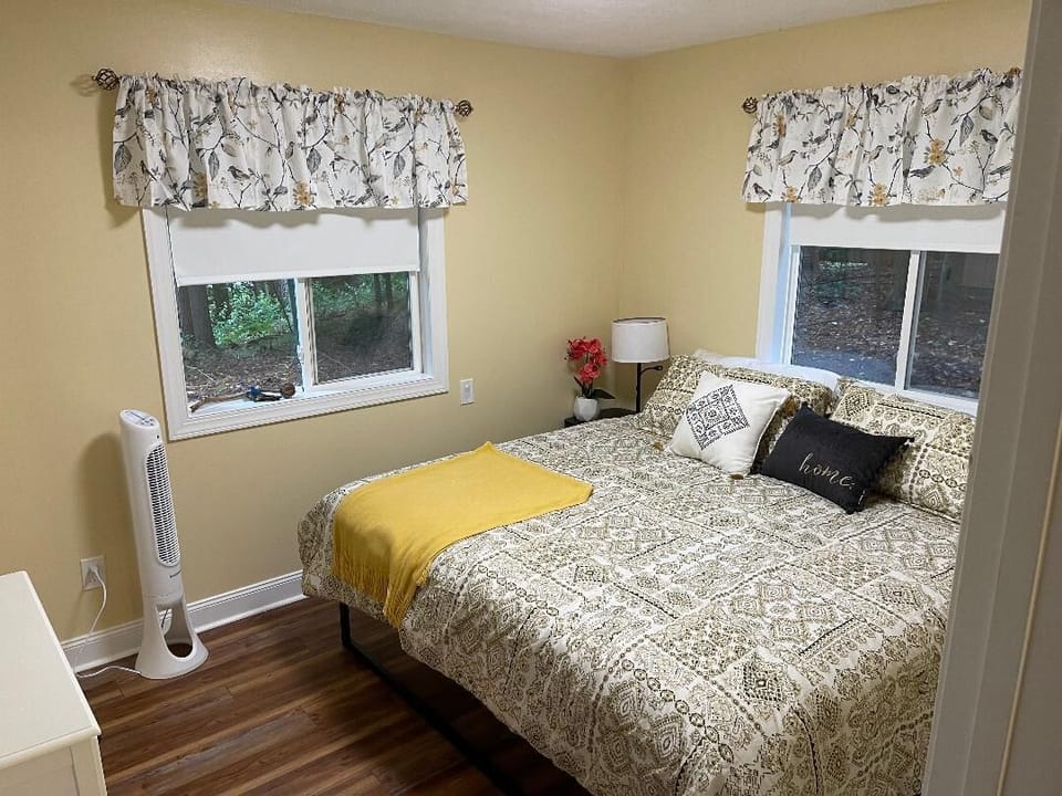 King Bed in the Bedroom with fan and dresser and cute walk in closet. 