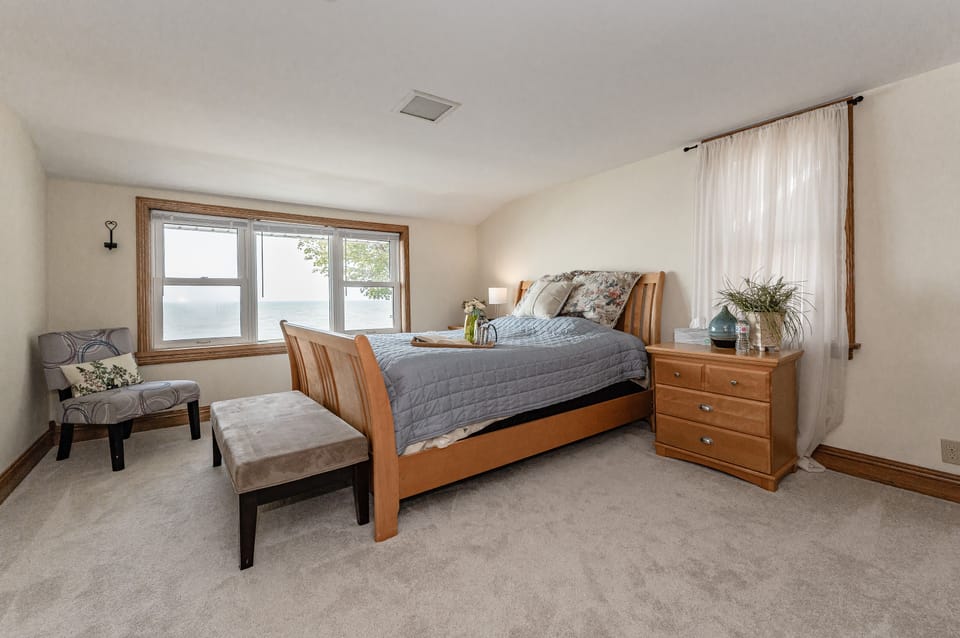 Upstairs lakefront primary bedroom with queen bed