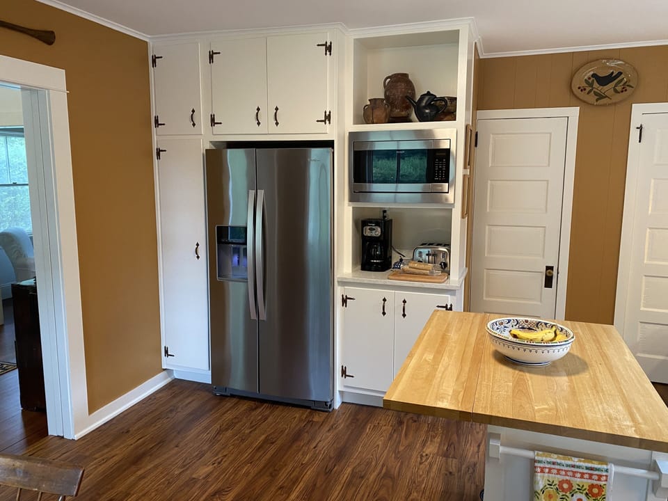 Coffee, toaster + microwave nook in kitchen, doorways to pantry +basement
