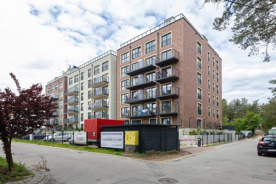 Modern apartment exterior located in a quiet, green neighborhood close to the beach.