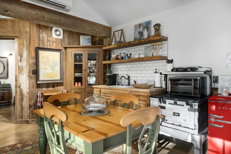 Gather around the wooden dining table for a home-cooked meal in our fully-equipped vintage kitchen. Guests say the rustic wood-paneled walls and retro red fridge give the space such a warm, authentic Texas feel.