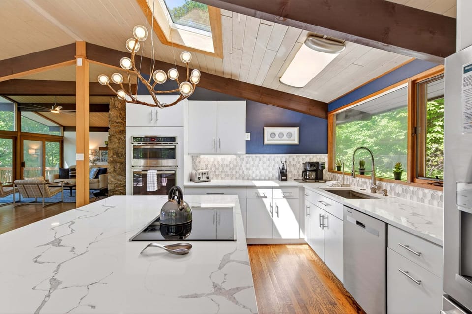 The gourmet GE kitchen with a vaulted ceiling & skylight is perfect for morning waffles, Vitamix smoothies, and every meal in between