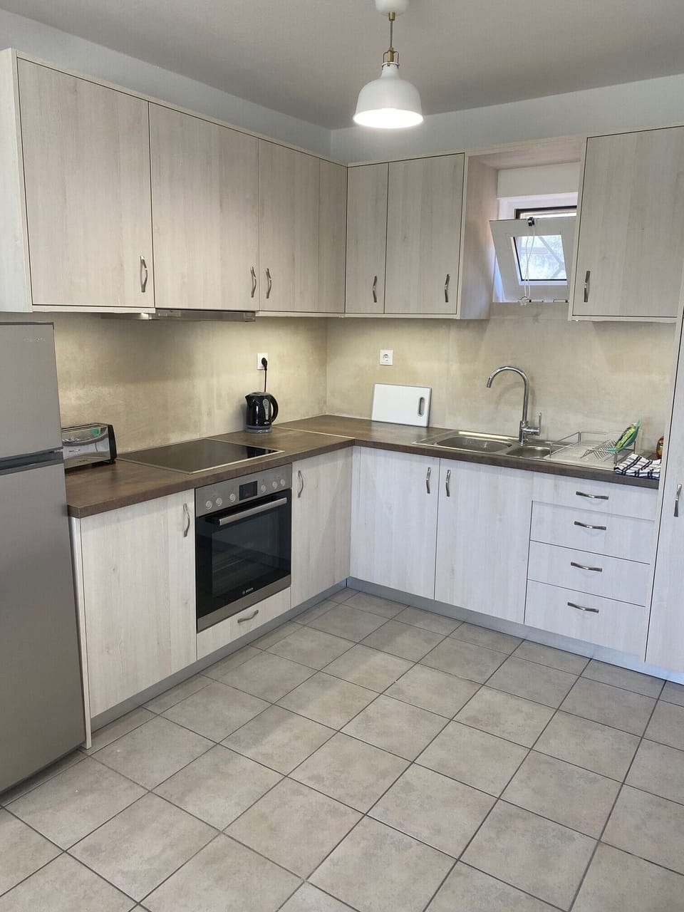 Newly fitted kitchen with, hob, oven, fridge and freezer.