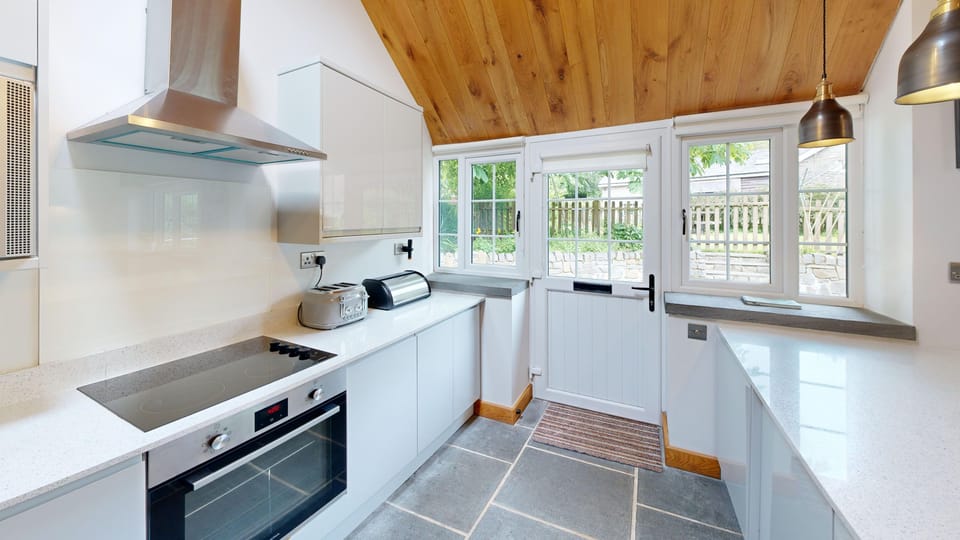 Fully equipped modern kitchen with sleek appliances and access to enclosed garden