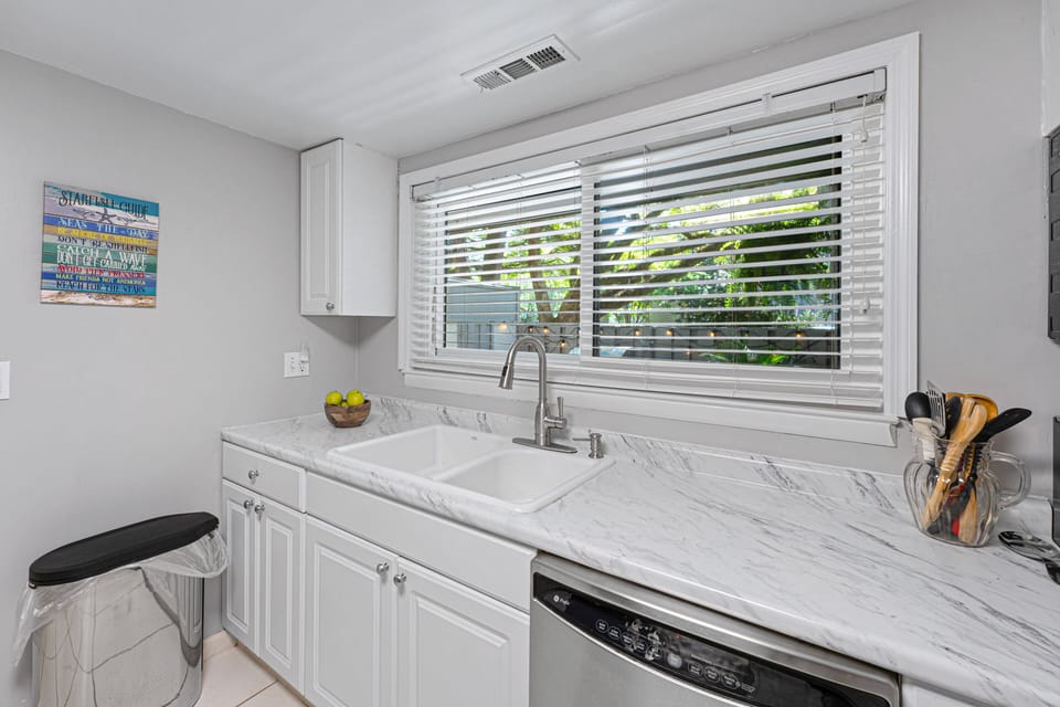 A large window over the sink brings in natural light and leafy views, creating a fresh, welcoming workspace.