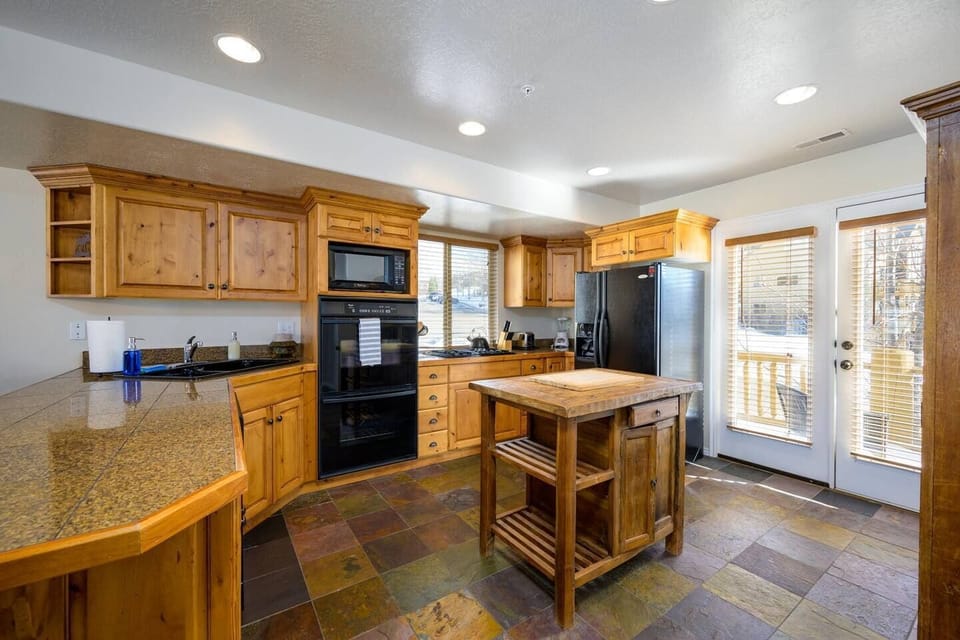 The gourmet kitchen features an island and is equipped with appliances, including a microwave, gas stove, and spacious refrigerator.