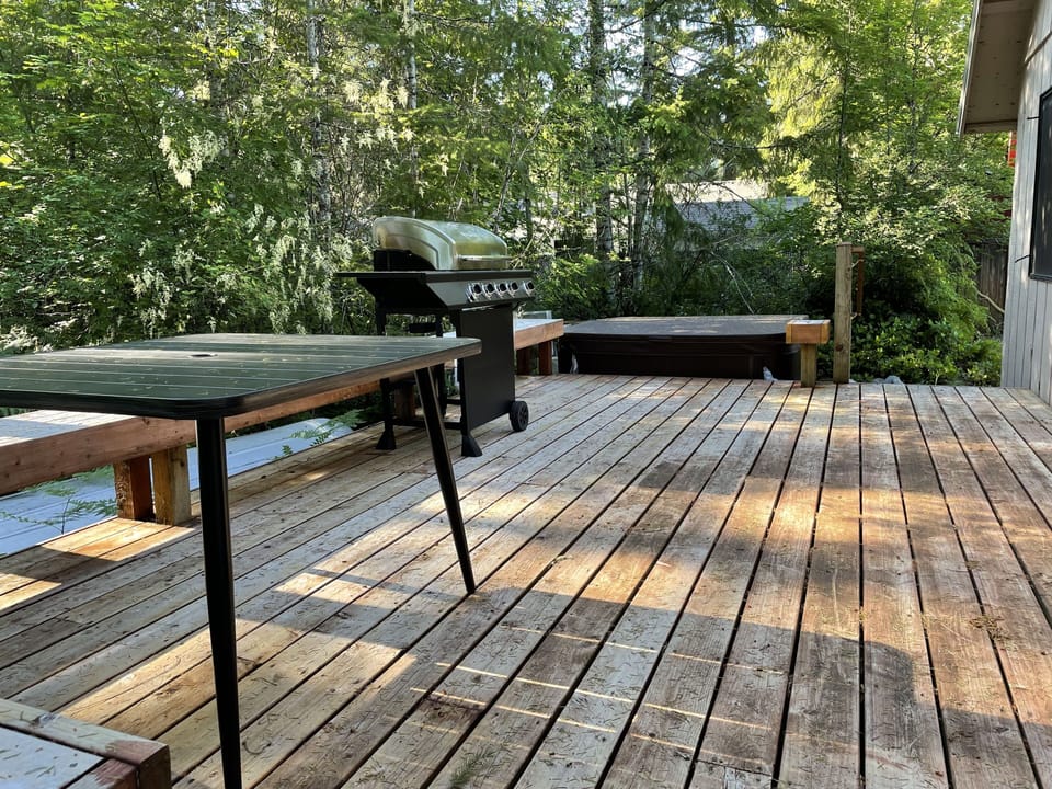 Back deck with BBQ and hot tub. Sliding doors lead into dining room.
