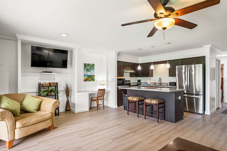 Movie nights land easily, the sectional facing the wall-mounted TV with the kitchen just behind.