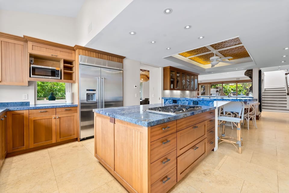 Step into your fully equipped gourmet kitchen with granite countertops, stainless steel appliances, and ample prep space. Natural light flows through tropical views while you cook.