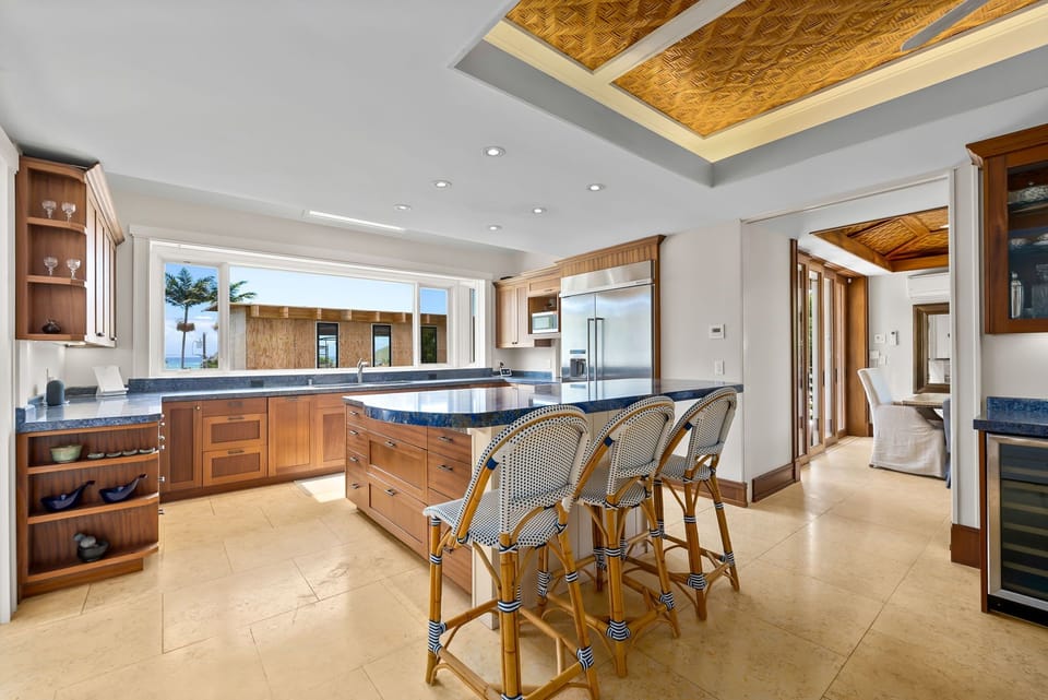 Your gourmet kitchen awaits with custom cabinetry, ocean views, and a welcoming island where you can gather for meals and conversation in tropical elegance.