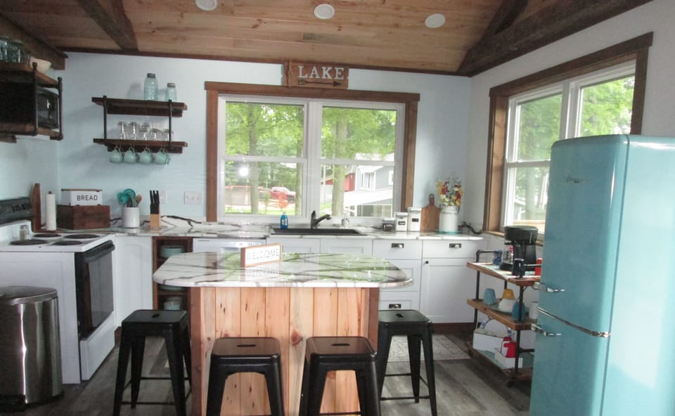 Main floor kitchen with vintage  refrigerator; island seats 4 with lake view