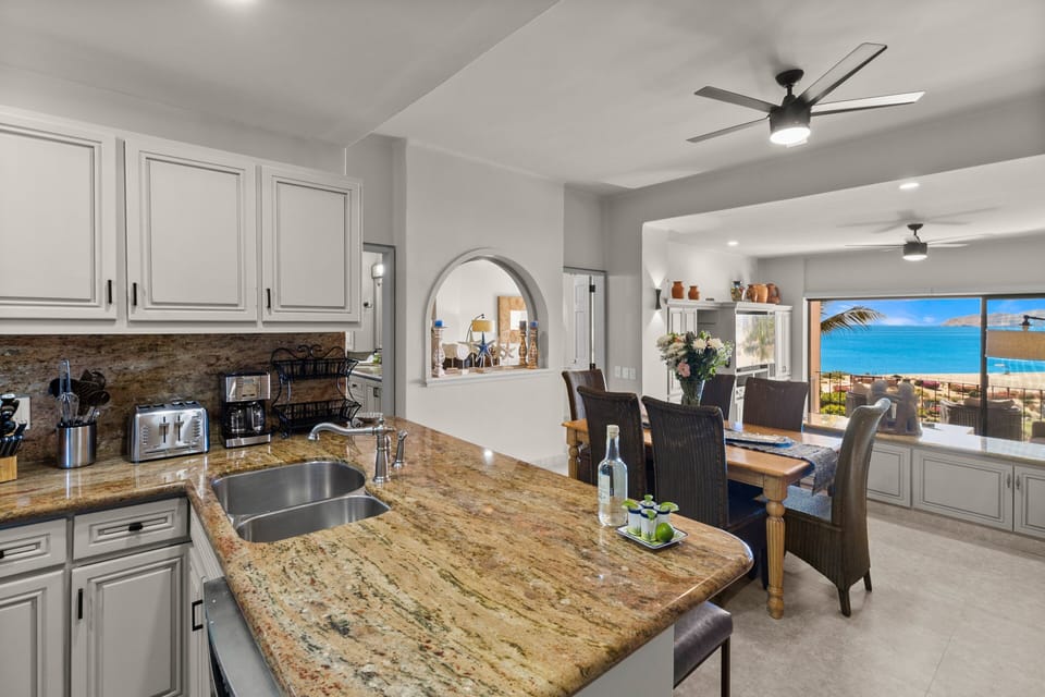 Renovated kitchen with bar seating, 6-seat dining table and ocean views.
